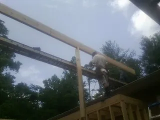 Carpenter setting a ridge beam over a new addition frame — Ice Dam Removal by Roofing Brothers in River Rouge