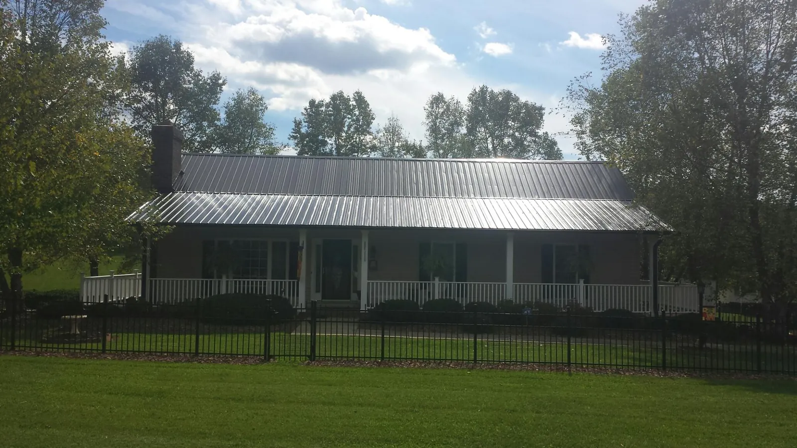 Gray metal roof on a brick ranch with a full width front porch — Gutter Guard Installation work by our crew in River Rouge