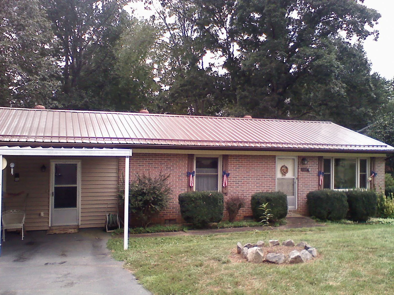 Bronze metal roof and carport on a brick ranch home — Roof Repair work by our crew in River Rouge